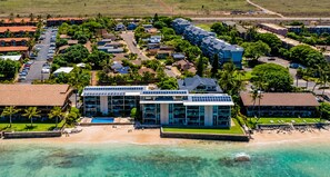 Ein Hotel an der Küste mit mehreren Gebäuden, einem Strand und einem Pool.