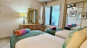 A hotel room with two beds, a dresser, a mirror, a fan, and a ceiling fan. - Welcome to our beachfront Maui 'Ohana! - Steps to the beach! (Lahaina)
