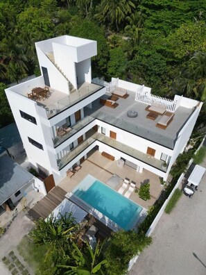 A modern multi-story house with a rooftop pool, outdoor seating, and lush greenery surrounding the property. - Chic 6-bedroom Chalet in Goidhoo, Baa Attol (Goidhoo)