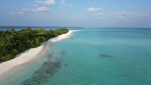 Ein Strand mit klarem türkisblauem Wasser und einem sandigen Ufer.