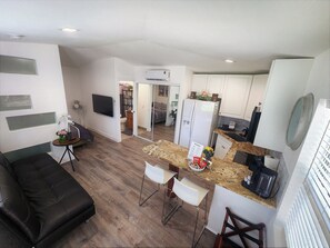 A modern apartment with a living room, kitchen, and dining area.