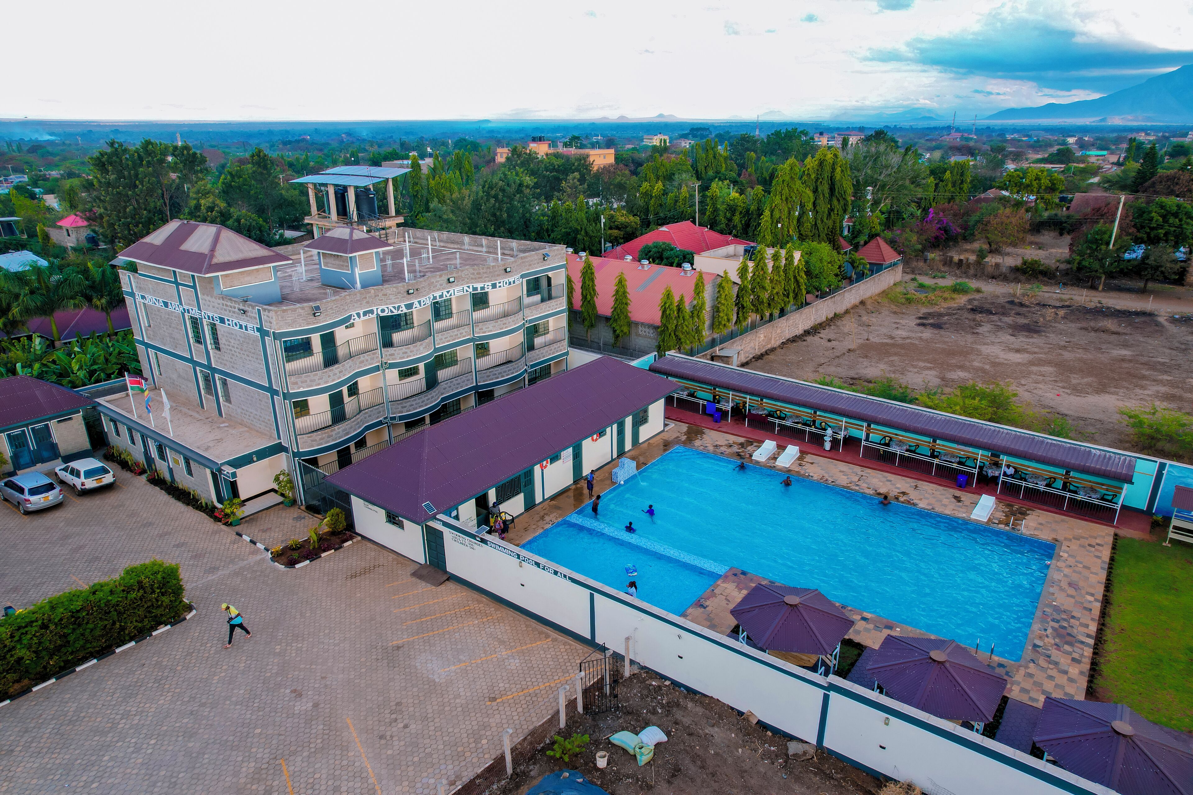 A hotel with multiple buildings, a swimming pool, and a view of the surrounding landscape.