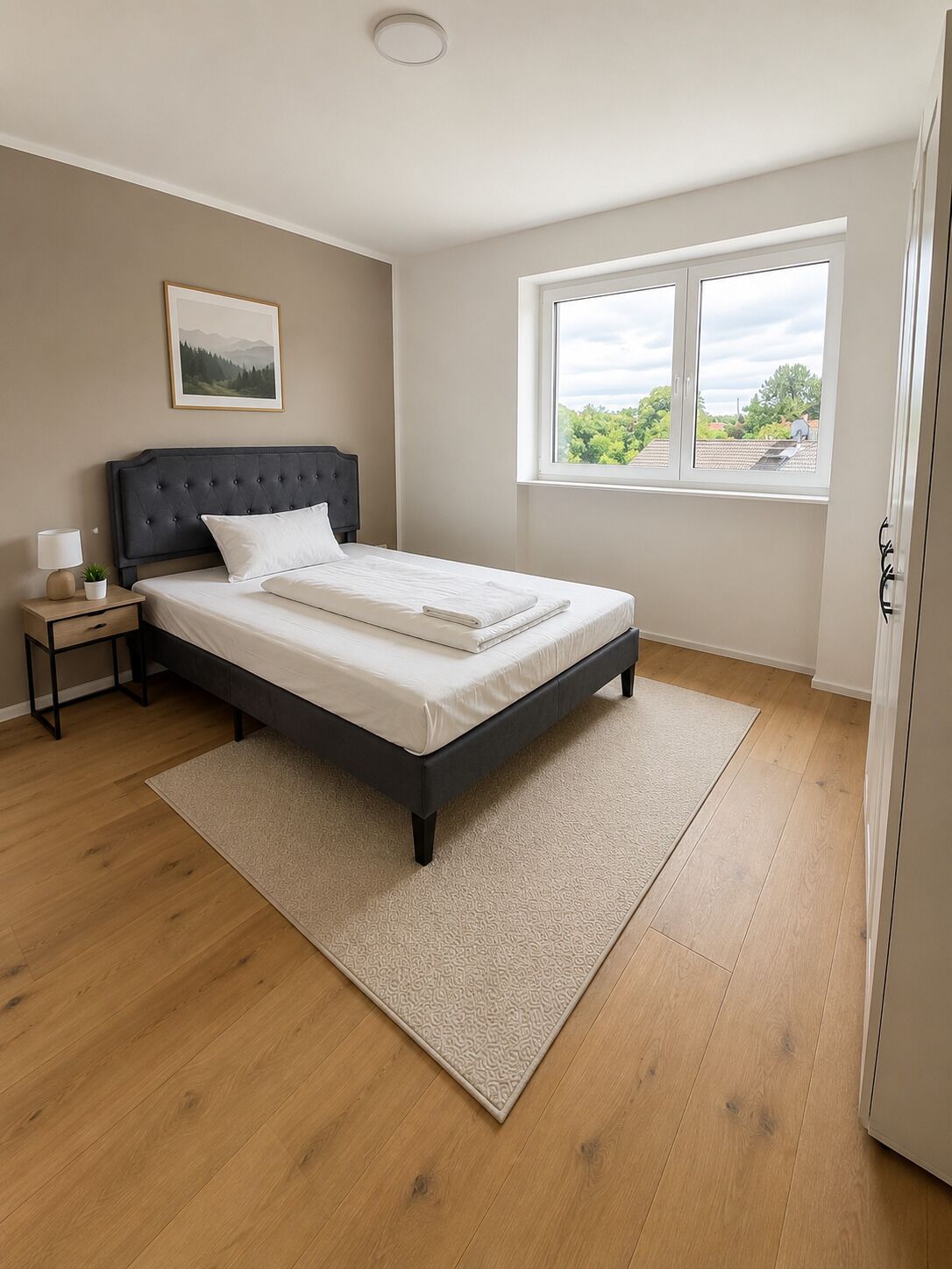 Une chambre à coucher avec un lit, une table de chevet, une fenêtre et une porte.