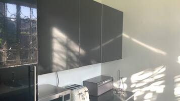 A kitchen with a microwave, toaster, and a cabinet.