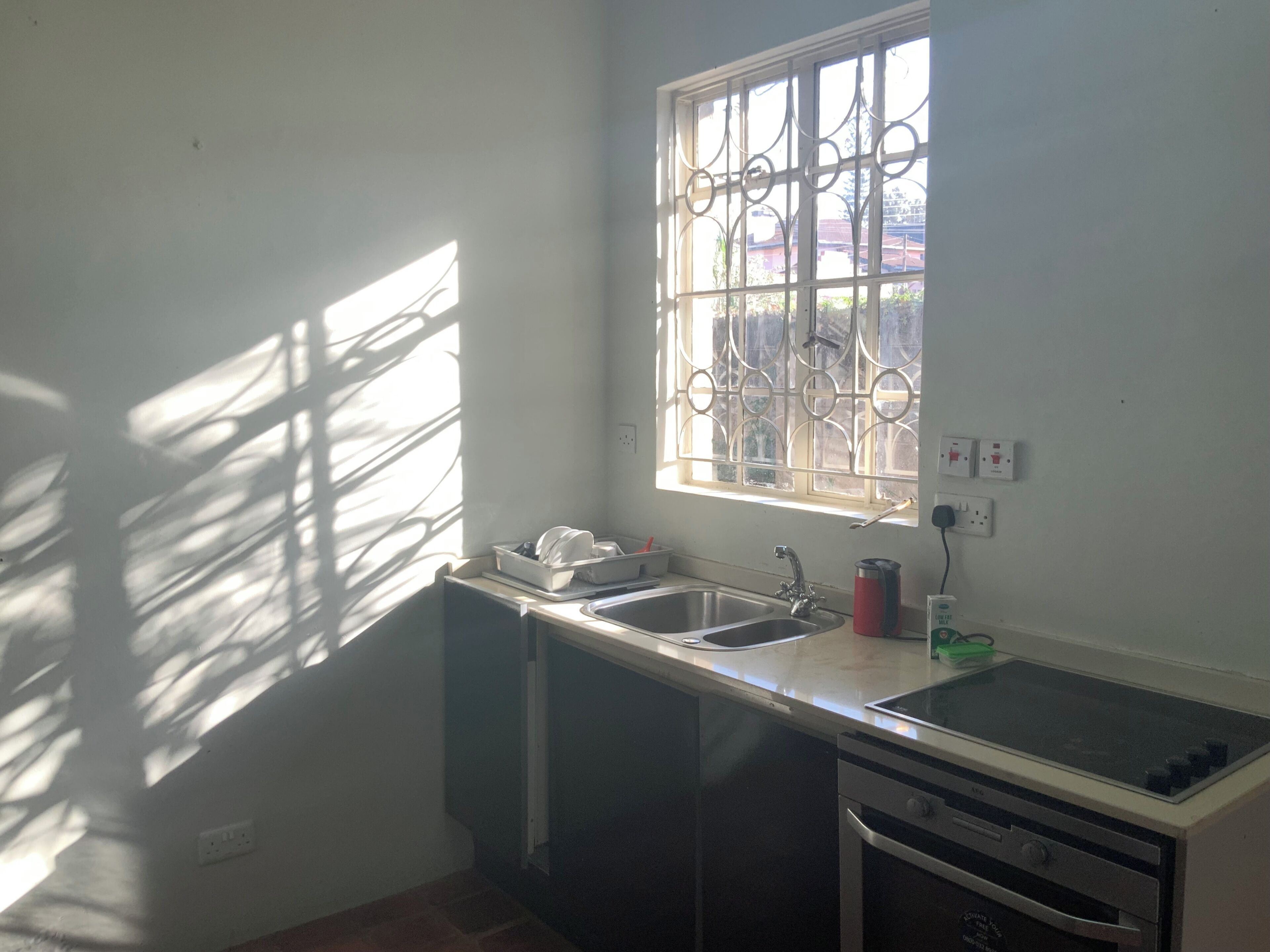 A kitchen with a window, sink, and stove.