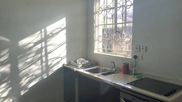 A kitchen with a window, sink, and stove.