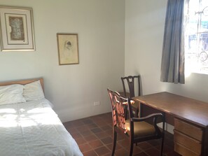 A room with a bed, a desk, and chairs. There are two framed pictures on the wall. - Adorable 2-bedroom bungalow in Nairobi perfect for relaxing stays (Nairobi)