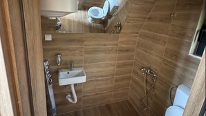 Ein kleines Badezimmer mit Toilette, Waschbecken und Dusche.