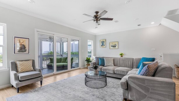 A spacious living room with a grey sofa, a round coffee table, and a ceiling fan. - 🐾 Supplication | Pet Friendly Townhome at Lost Key Golf and Beach Club (Perdido Key)