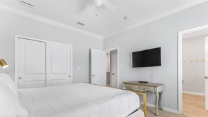 A bedroom with a bed, a desk, a television, and a door leading to another room. - 🐾 Supplication | Pet Friendly Townhome at Lost Key Golf and Beach Club (Perdido Key)