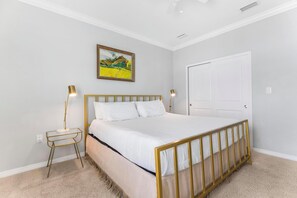A bedroom with a bed, bedside lamps, a door, and a painting on the wall. - 🐾 Supplication | Pet Friendly Townhome at Lost Key Golf and Beach Club (Perdido Key)