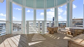 A covered outdoor deck with wooden furniture and a view of the city. - 🐾 Supplication | Pet Friendly Townhome at Lost Key Golf and Beach Club (Perdido Key)