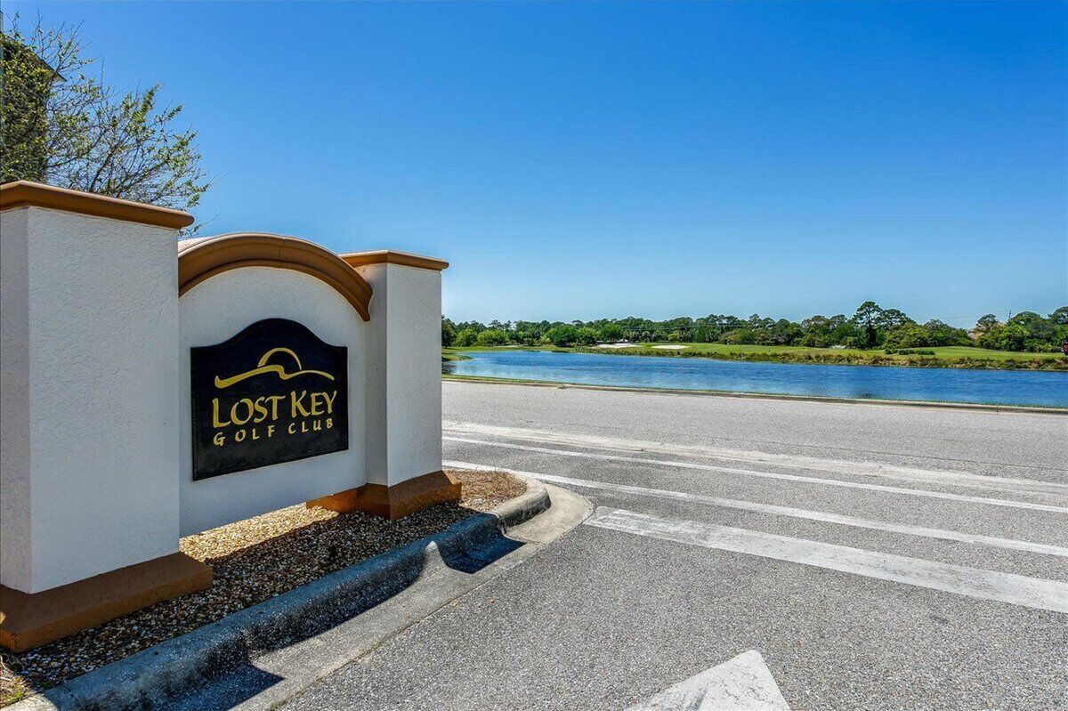 L’entrée d’un club de golf offrant une vue dégagée sur un lac et sur la verdure environnante.