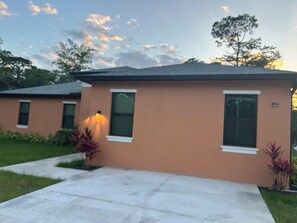 A two-story building with a flat roof, a front entrance, and a pathway leading to the door. - Enjoyable 5-bedroom house with AC in charming Naples (Naples)