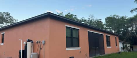 A single-story building with a flat roof, a large window on the side, and a door.