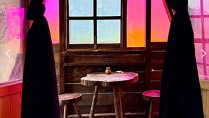 A room with a wooden table and two stools, a window, and a door.