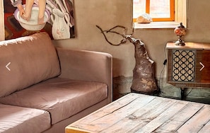A living room with a sofa, a wooden coffee table, a decorative vase, and a vintage radio.