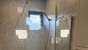 Un bany amb dutxa, vàter i rentatge.