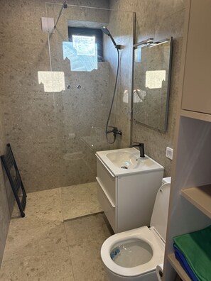 Kylpyhuone, jossa on suihku, wc ja pesuallas.
