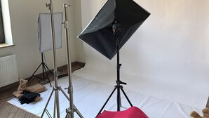 Un estudi amb equip d'il·luminació i un fons, que indica un espai per a fotografia o videografia.