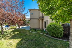 A residential building with a well-maintained lawn, a driveway, and a tree with red leaves. - Relocation Home | Workspace, Garage, Elevator, W&D (North Salt Lake)