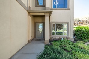 A building entrance with a door, a small covered porch, and a window. - Relocation Home | Workspace, Garage, Elevator, W&D (North Salt Lake)