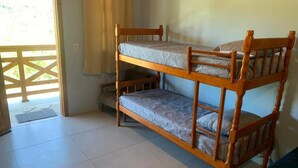 A bunk bed with a lower bunk, a door leading outside, and a window with curtains. - Pousada Santa Rosa (Imbituba)