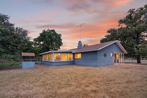 Une maison à deux étages avec un garage, un patio couvert et un grand jardin.