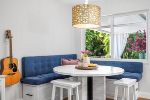 Ein Zimmer mit einem blauen Sofa, einem runden Tisch und einer Gitarre.
