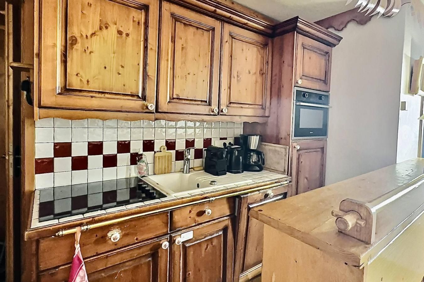 Una cocina con armarios de madera, salpicadero de azulejos y una estufa.