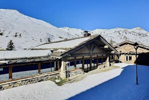 A snow-covered mountain lodge with a wooden exterior and a covered porch. - 380m from ski slopes, 1st floor, view mountain, balcony, tv, ski locker, 59m², Tignes (Tignes)