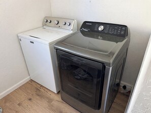 Un espace buanderie compact comprenant une machine à laver Maytag blanche et un sèche-linge Samsung.