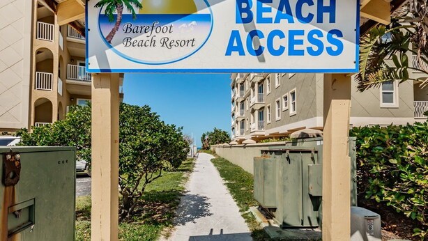 Schild für das Barefoot Beach Resort, das den Zugang zum Strand anzeigt.