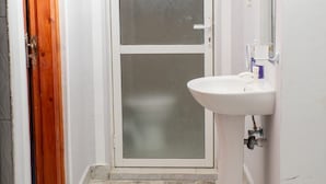 A bathroom with a white sink, a mirror, and a frosted glass door. - ✨ Stylish Malindi 1BR Retreat | Cozy, Bright & Peaceful. Family -friendly (Malindi)