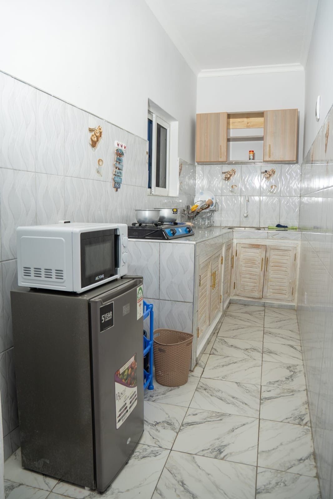 Una cocina compacta equipada con refrigerador, microondas y estufa.