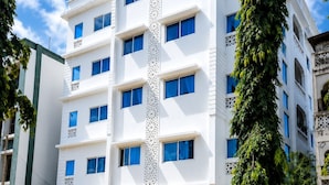 A multi-story building with a white facade and blue windows. - ✨ Stylish Malindi 1BR Retreat | Cozy, Bright & Peaceful. Family -friendly (Malindi)