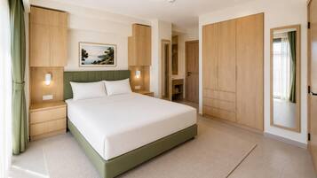 A modern bedroom with a large bed, wooden wardrobe, and a nightstand with a lamp.