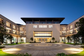 A modern building with a central courtyard, multiple floors, and large windows. - Days Hotel By Wyndham Yangxin Xiandao Lake (Huangshi)