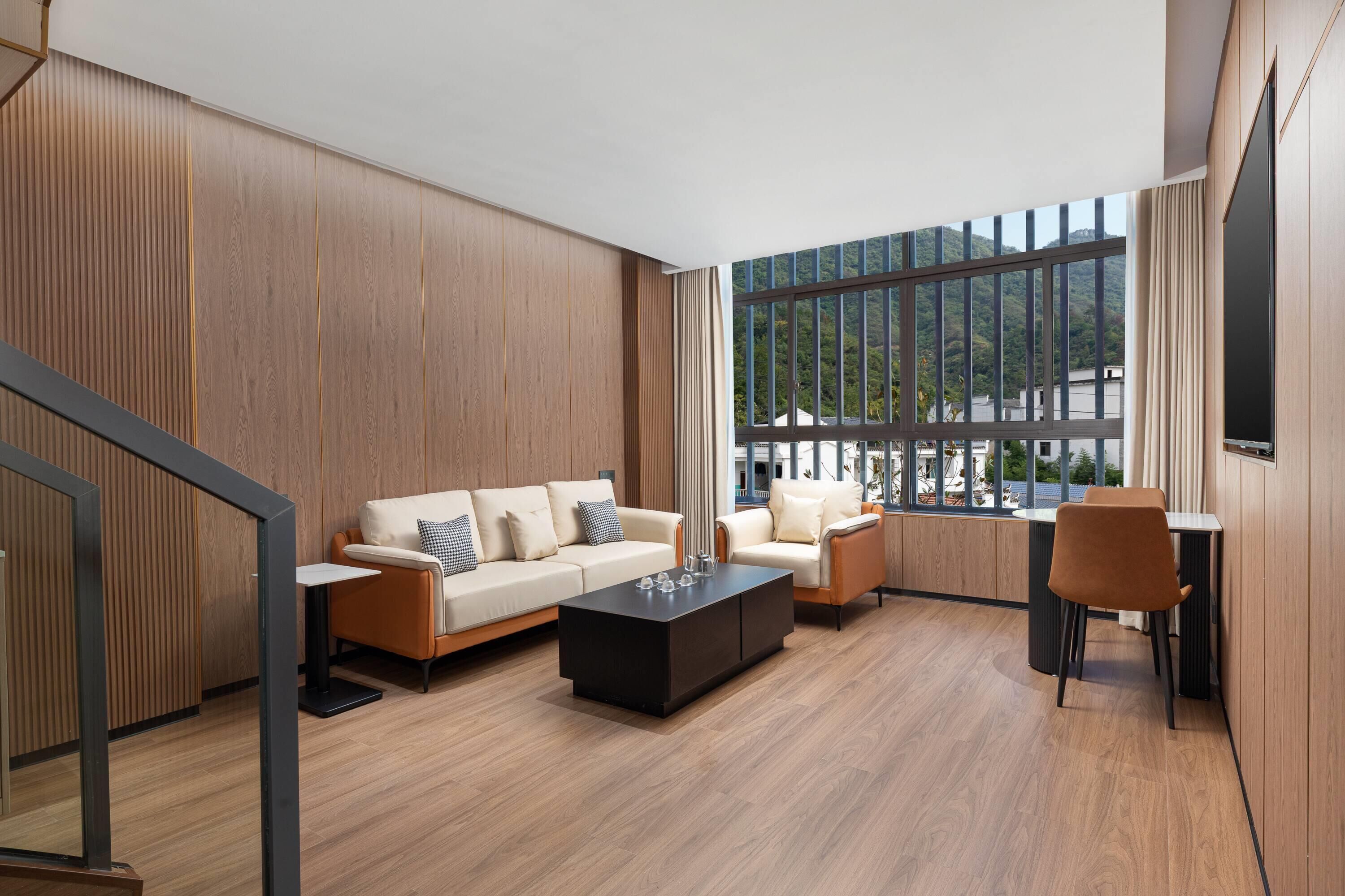 A modern living room with a sofa, armchairs, a coffee table, and a dining area.