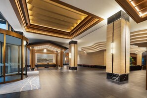 A spacious lobby with a reception desk, seating area, and a large window with a view. - Wyndham Lishui Liandu Resort (Lishui)