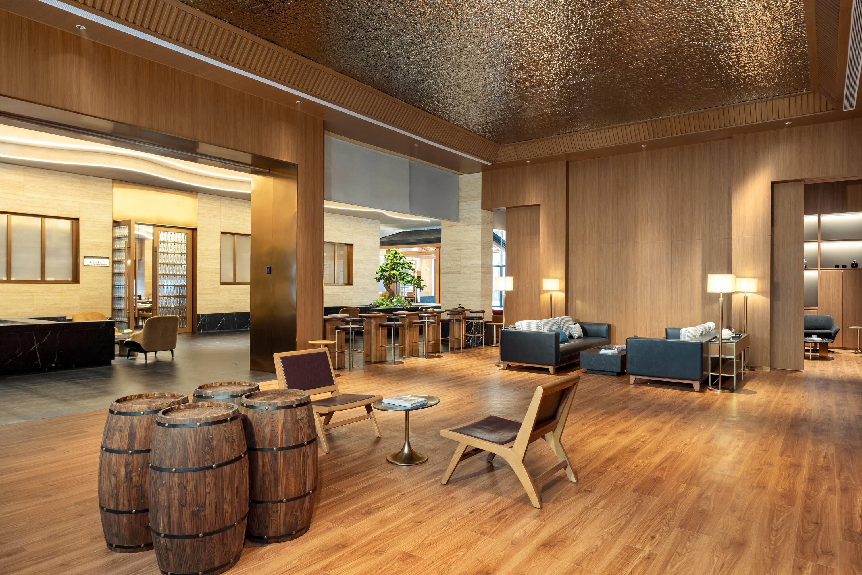 A spacious lobby with a reception desk, seating area, and a bar.