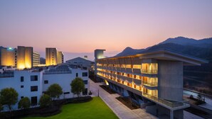 Un hotel moderno con estructura de varios pisos, techo plano y césped bien cuidado.