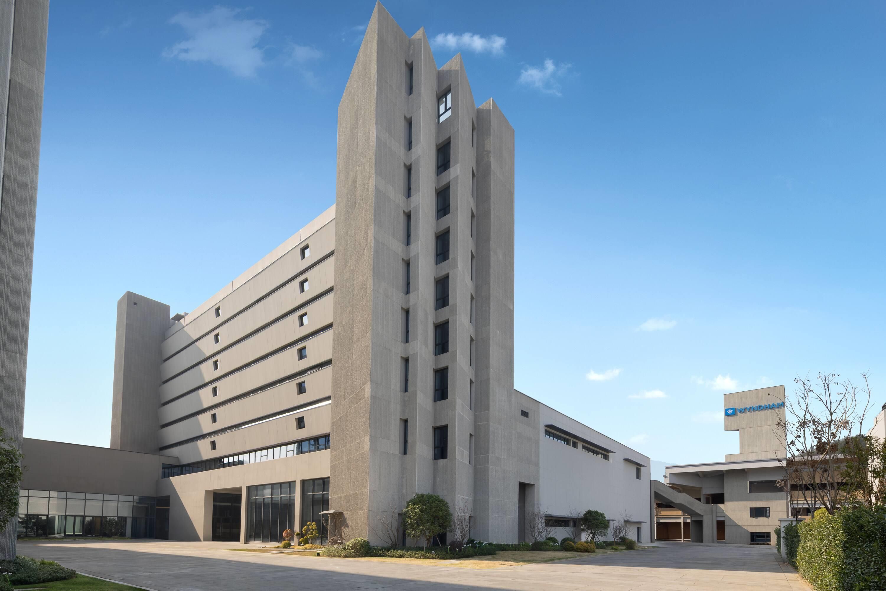 A modern building with a central tower, multiple floors, and a flat roof.