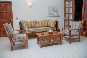 A living room with a sofa, two armchairs, a coffee table, and a wooden cabinet. - Tropical 2BR Malindi Condo | Pool & Balcony Views ❤️ (Malindi)