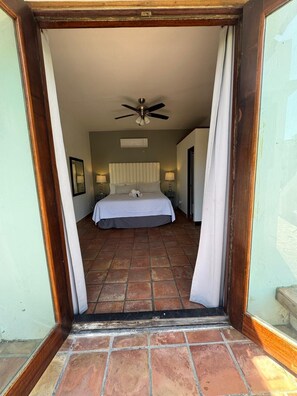 A bedroom with a bed, ceiling fan, and two bedside lamps. - Step to the beach /Beautiful Penthouse + Private Terrace (San Juan)
