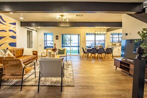 A modern living room with a sofa, chairs, and a dining area with a table and chairs.