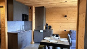 A modern kitchen with grey cabinets, a built-in microwave, and a dining area with a table set for four. - Balcony, tv, ski locker, 50m², Chamrousse (Chamrousse)
