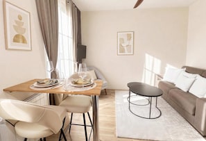 Una sala moderna con comedor, un sofá y una mesa de centro.