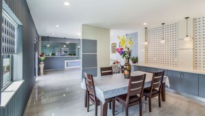 A modern dining area with a marble table, wooden chairs, and a vase of flowers. - Work, Rest & Recharge Near Pasadena l 2 Queen Suite w/ Kitchen (Deer Park)