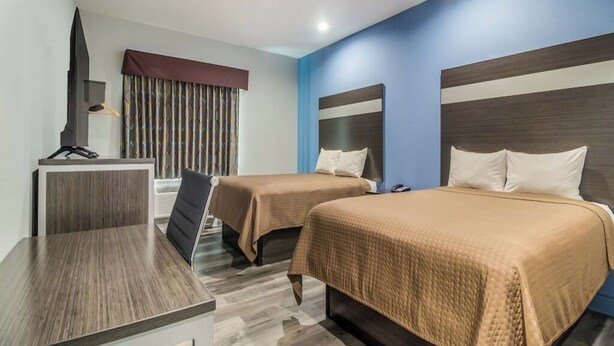 A hotel room with two beds, a desk, and a TV. - Work, Rest & Recharge Near Pasadena l 2 Queen Suite w/ Kitchen (Deer Park)